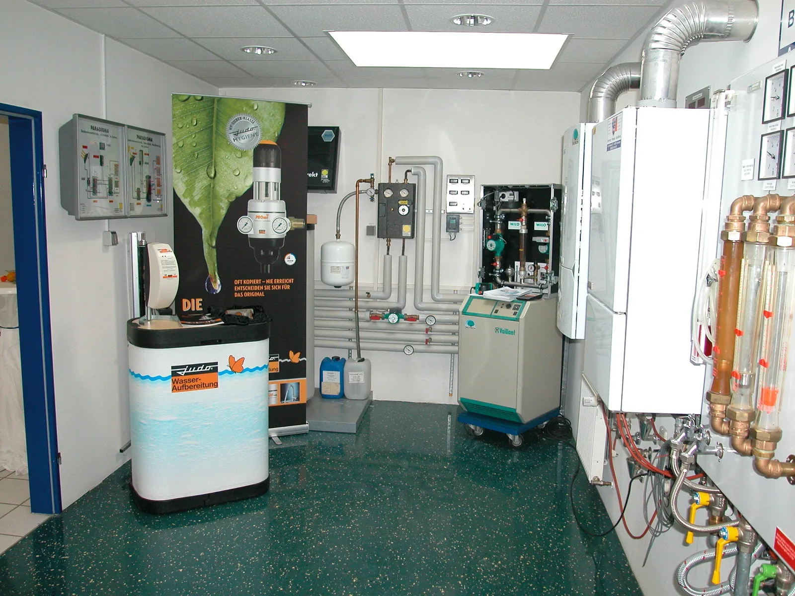 Ausstellungsraum mit Wandkesseln, Anlage zur Wasseraufbereitung und Schautafeln mit Pumpen und Leitungen